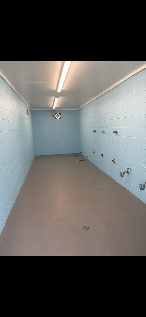 Commercial block restroom with blue walls and completed gray floor coating