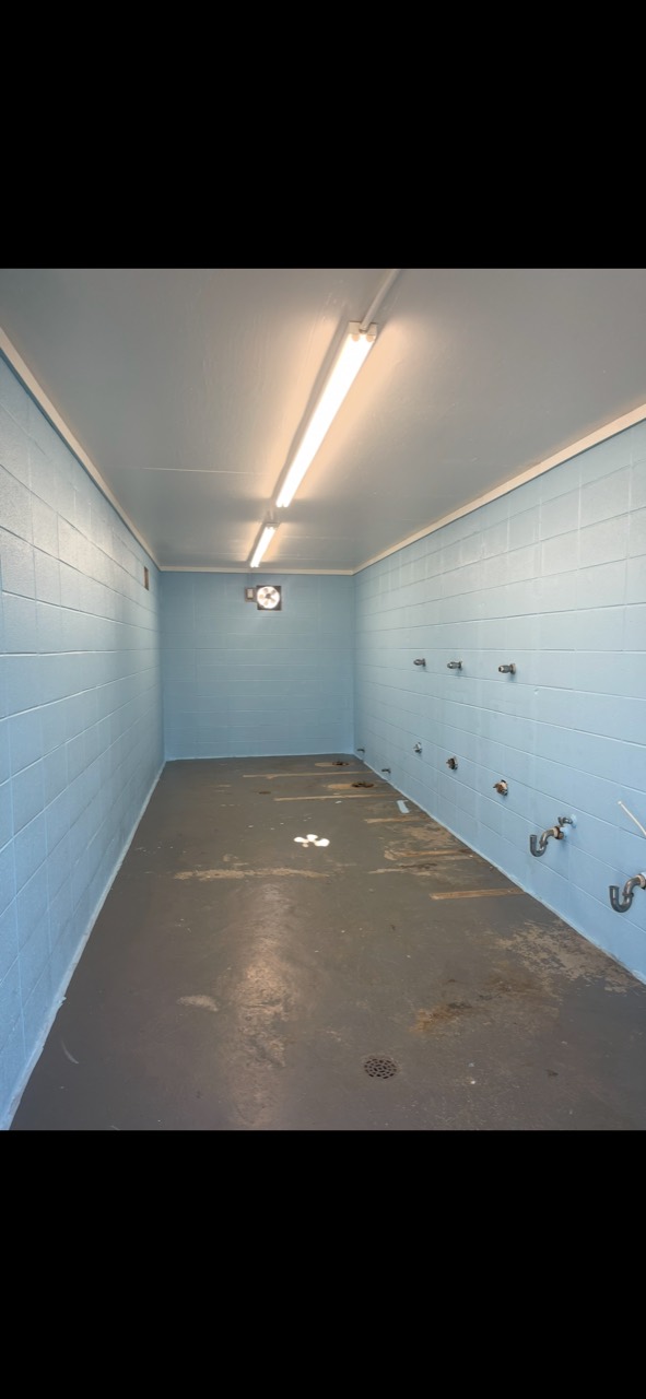 Commercial block restroom walls refinished in blue before floor completion