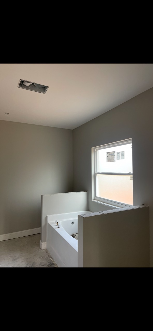 New-construction bathroom with finished walls and white trim