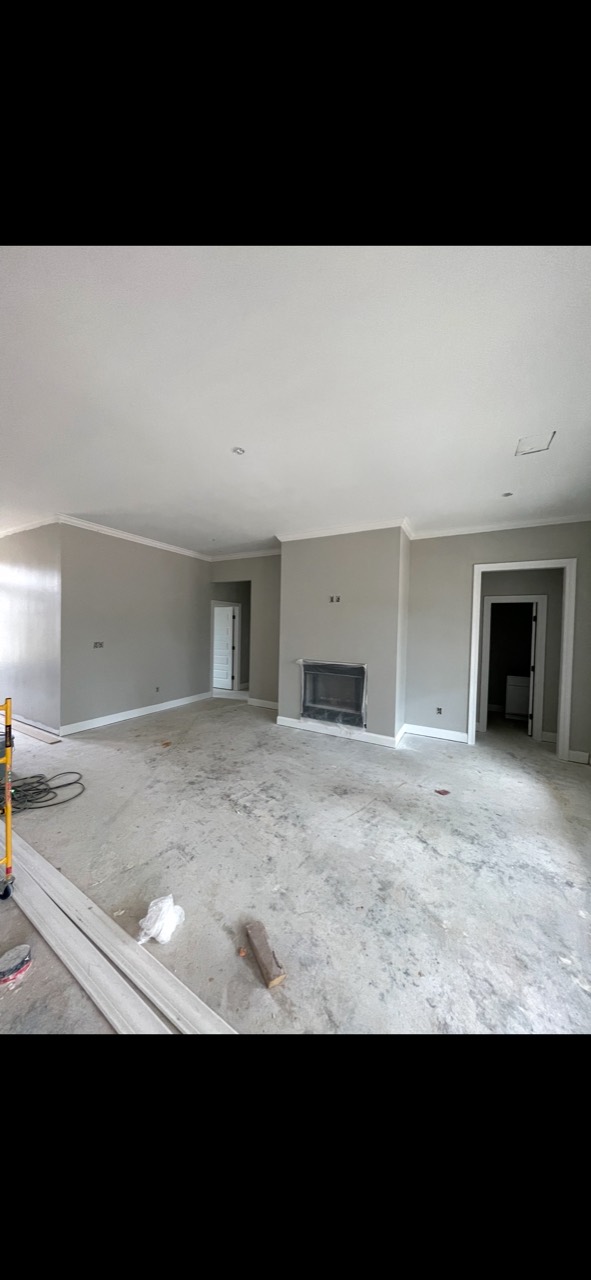 Finished living room walls, ceiling, trim, and fireplace surround